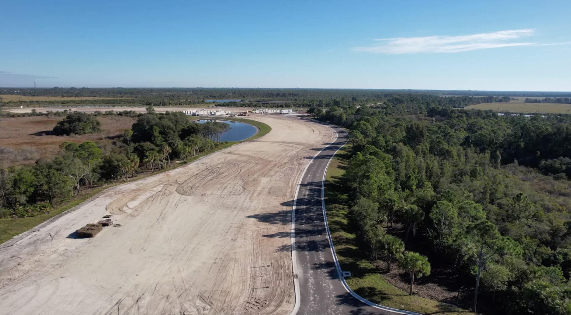 Aerial of a new roadway and cleared homesites beside a Florida preserve at a Sam Rodgers community
