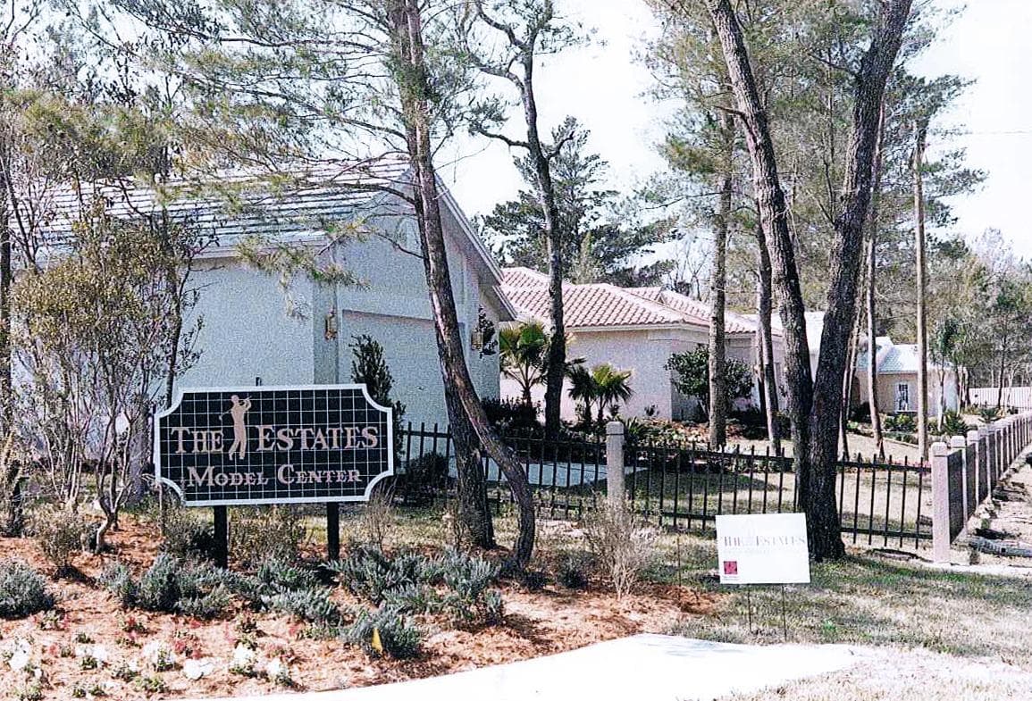 The Estates Model Center entrance sign in front of a Sam Rodgers model home