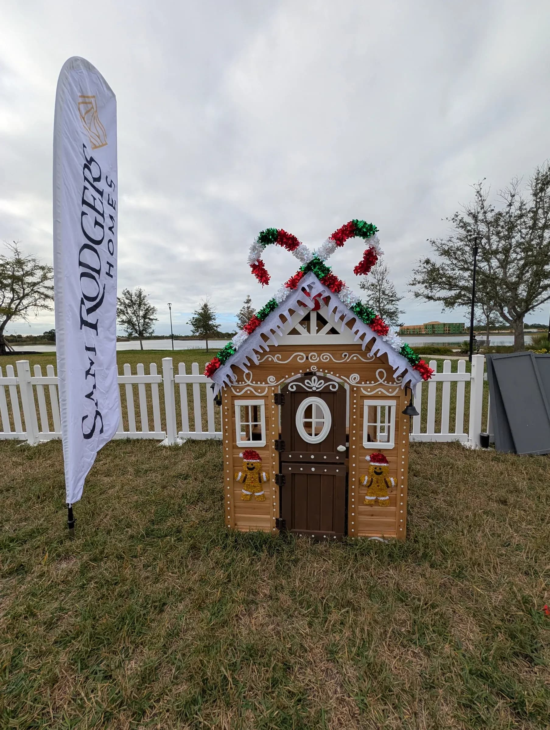 The finished gingerbread cottage under the Sam Rodgers Homes flag.